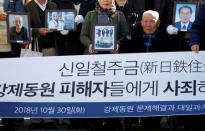 Lee Choon-shik, a victim of wartime forced labor during the Japanese colonial period, arrives with supporters holding portraits of fellow deceased laborers in Seoul, South Korea, October 30, 2018. The banner reads "Nippon Steel & Sumitomo Metal Corp apologize to wartime forced labors and compensate them". REUTERS/Kim Hong-Ji