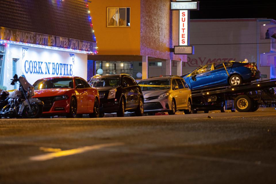 A blue Honda is loaded onto a flatbed tow truck in Wildwood, New Jersey, late Saturday, Sept. 24, 2022. Authorities say at least two people were killed amid multiple crashes at a pop-up car rally.