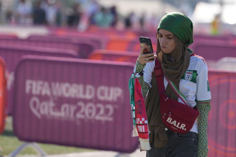 Una hincha iraní afuera del estadio Internacional Jalifa espera por el partido entre Inglaterra e Irán