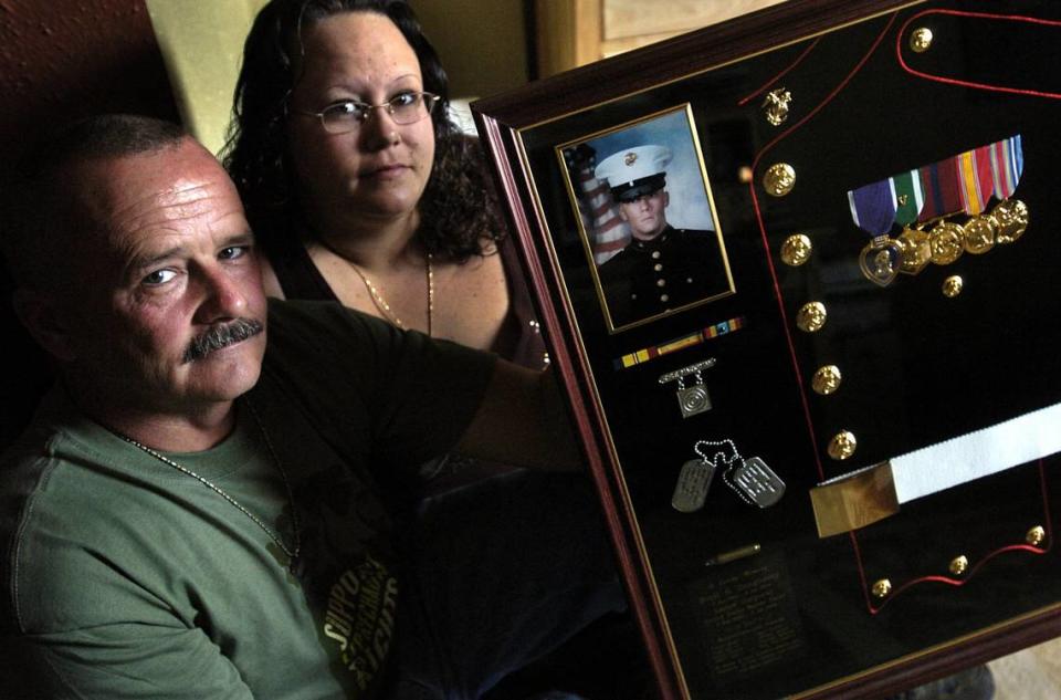 Keith Dougherty and his daughter, Nicole, hold a shadow box filled with the medals, dog tags, and a photo of Lance Cpl. Scott Dougherty on March 17, 2006. Scott, Keith’s son and Nicole’s brother, was a Marine killed in action in Iraq in 2004 as a result of enemy action near Al Anbar Province.
