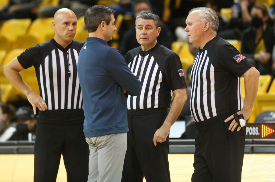 Delaware coach Martin Ingelsby confers with officials as the Blue Hens' visit to Towson in Towson, Md., was suspended due to unsafe court conditions Thursday, Jan. 27, 2022.