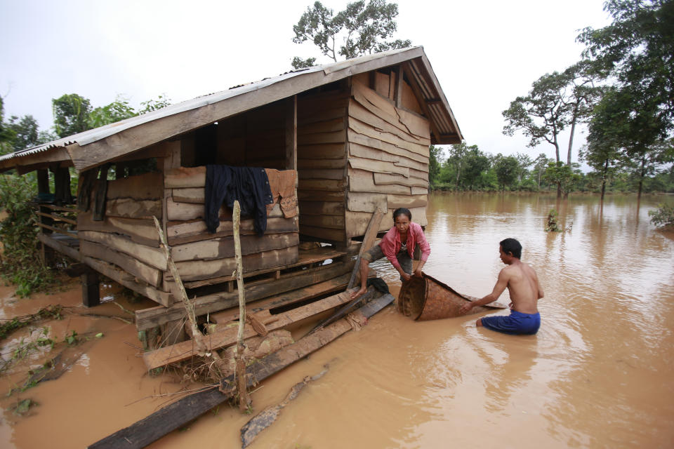 <p>Kongvilay Inthavong and his wife Thongla clean up their house as the floodwaters start to recede i in Sanamxay district, Attapeu province, Laos on Thursday, July 26, 2018. (Photo: Hau Dinh/AP) </p>