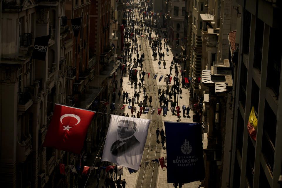 An image of Mustafa Kemal Ataturk, hangs next to a national flag over Istiklal Street, in Istanbul, Turkey, Wednesday, Oct. 25, 2023. The Turkish Republic, founded from the ruins of the Ottoman Empire by the national independence hero Mustafa Kemal Ataturk, turns 100 on Oct. 29. Ataturk established a Western-facing secular republic modeled on the great powers of the time, ushering in radical reforms that abolished the caliphate, replaced the Arabic script with the Roman alphabet, gave women the vote and adopted European laws and codes. (AP Photo/Emrah Gurel)