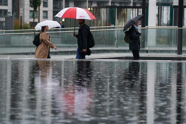 People walk in the rain