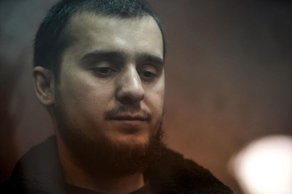 Dilovar Islomov, 23, stands inside the defendant cage as he waits for his pre-trial detention hearing at the Basmanny District Court in Moscow on March 25, 2024. Islomov was arrested in connection with the March 22 mass shooting at Crocus City Hall in Moscow. He allegedly sold a car to the perpetrators. (Tatyana Makeyeva / AFP via Getty Images)