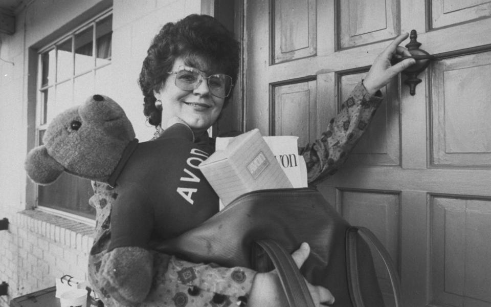 An 'Avon lady', June Young, who goes door to door with cosmetic products and an Avon teddy bear, knocks on the door during a sales visit