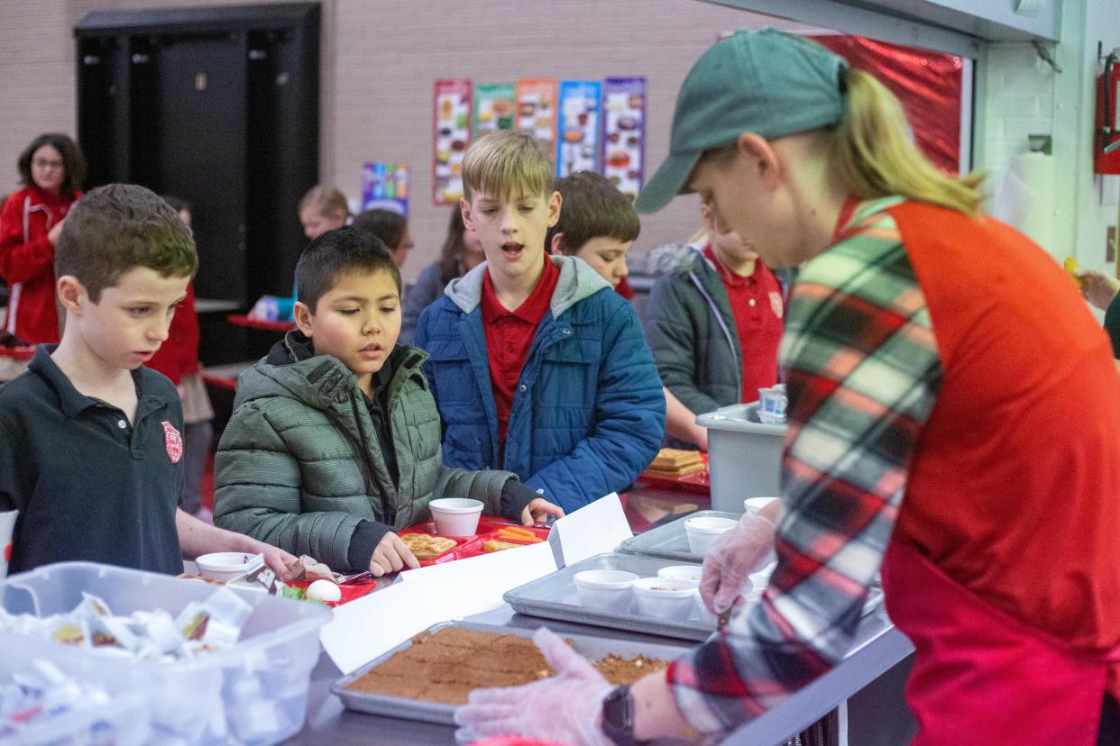 Kyleen Harris, food service director at Manhattan Catholic Schools, serves and explains the locally grown ingredients in each of the three food items that were tested at the school Thursday.