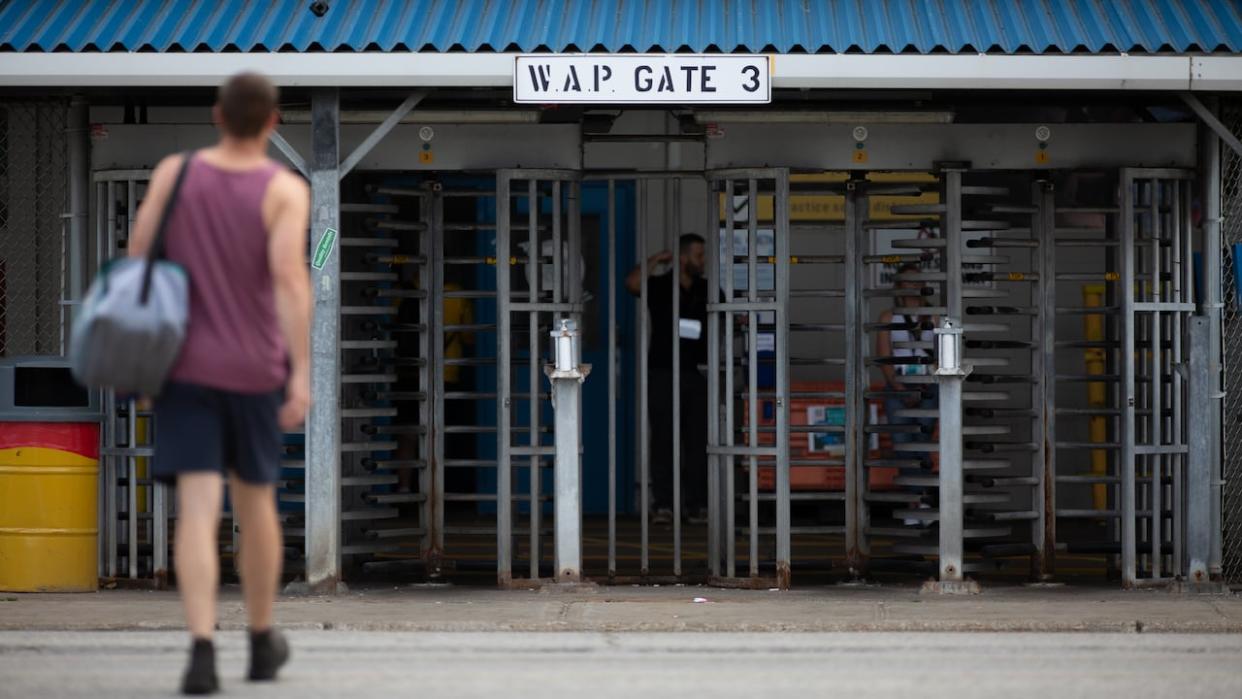 A worker walks towards the gate of the Windsor Assembly Plant on Thursday, Aug. 10, 2023. Bargaining with the Detroit Three automakers got underway in August, and Stellantis is the final company to negotiate a deal with Unifor. (Dax Melmer/CBC - image credit)