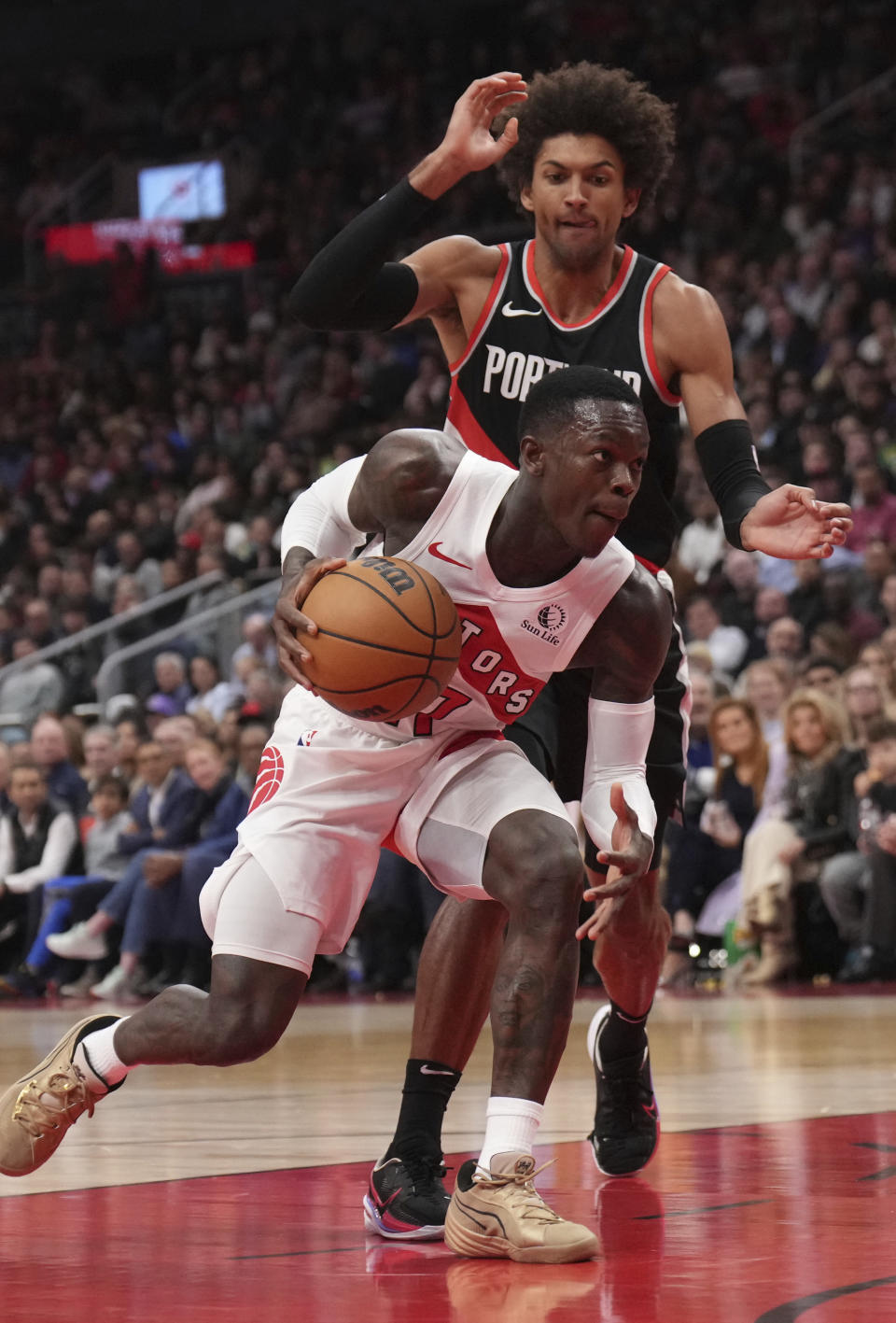 Toronto Raptors guard Dennis Schroder, bottom, moves around Portland Trail Blazers guard Matisse Thybulle, top, during first-half NBA basketball game action in Toronto, Monday, Oct. 30, 2023. (Nathan Denette/The Canadian Press via AP)