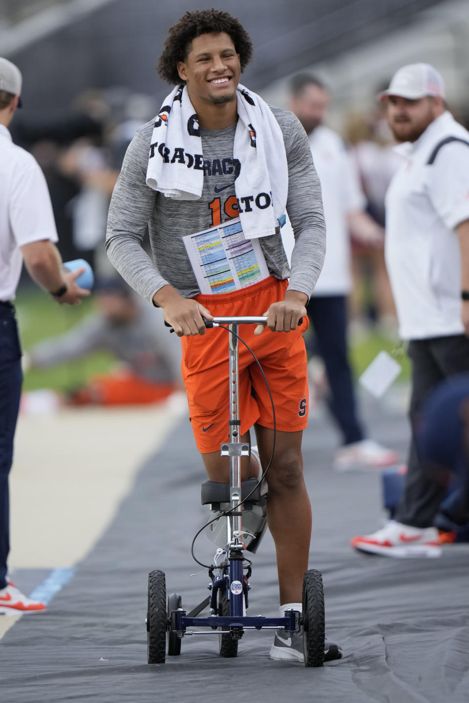 Syracuse tight end Oronde Gadsden II uses a knee scooter on the sidline during warmups for the team's NCAA college football game against Purdue in West Lafayette, Ind., Saturday, Sept. 16, 2023. Due to an injury suffered while playing against Western Michigan, Gadsden is expected to be out the rest of the season. (AP Photo/AJ Mast)