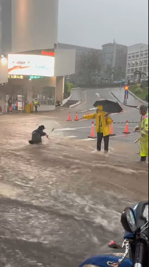 弘光科大前淹水變成急流，女學生撐傘涉水而過，慘遭湍急洪水沖走，險象環生。(圖／翻攝自記者爆料網)