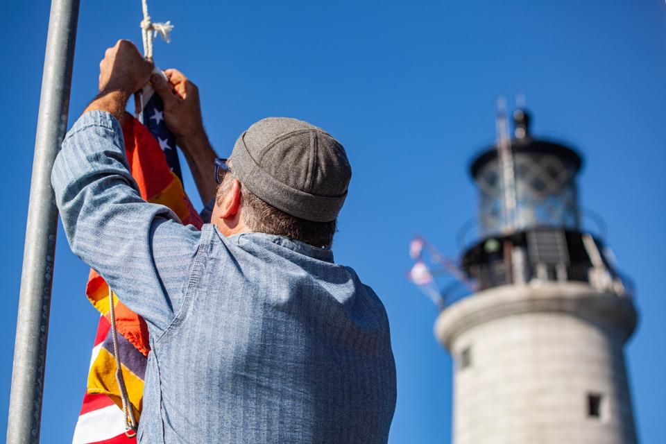 Dave Waller installs a flag at the Graves Light Station on Thursday, June 23, 2022.