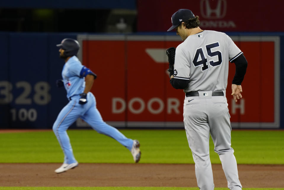 New York Yankees starting pitcher Gerrit Cole (45) looks down as Toronto Blue Jays second baseman Marcus Semien (10) rounds the bases after hitting a home run during the first inning of baseball game in Toronto on Wednesday, Sept. 29, 2021. (Frank Gunn/The Canadian Press via AP)