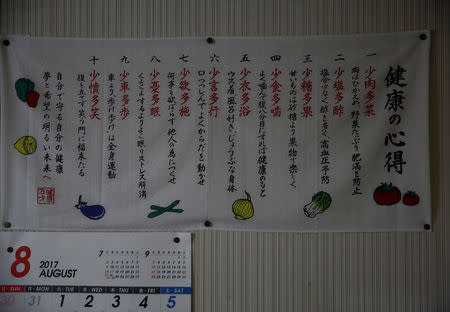 A banner featuring tips for staying healthy hangs on the wall of Katsuo Saito's room in Tokyo, Japan, September 7, 2017. REUTERS/Kim Kyung-Hoon
