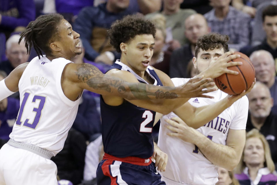 Gonzaga's Anton Watson, center, tries to keep the ball between Washington's Hameir Wright (13) and Sam Timmins in the first half of an NCAA college basketball game Sunday, Dec. 8, 2019, in Seattle. (AP Photo/Elaine Thompson)