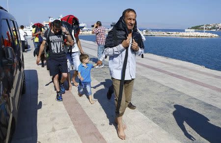 Syrian migrants walk on the shore in Cesme, near the Aegean port city of Izmir, Turkey, August 11, 2015. REUTERS/Osman Orsal