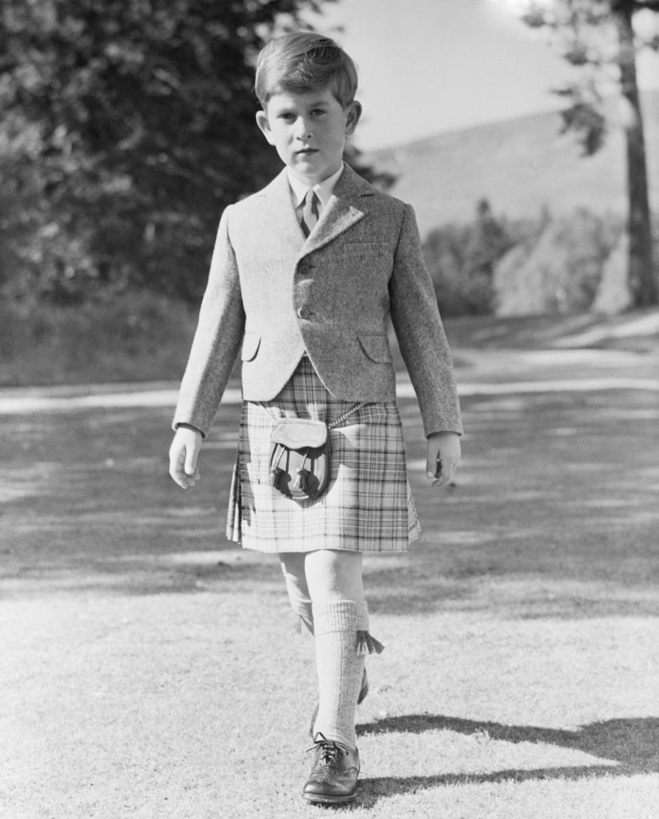 (Original Caption) All This and Seven, Too. Balmoral, Scotland: Resplendent in a kilt of Balmoral tartan, restricted to members of the royal family, Prince Charles, son of Queen Elizabeth II and the Duke of Edinburgh, poses for this 7th birthday portrait in the grounds of Balmoral Castle. The young prince looks very much like his father. For now on he will begin his training for kingship. Charles' full title is Prince Charles Arthur George, duke of Cornwall and Rothesay, earl of Carrick, baron Renfrew, lord of the isles and great steward of Scotland.