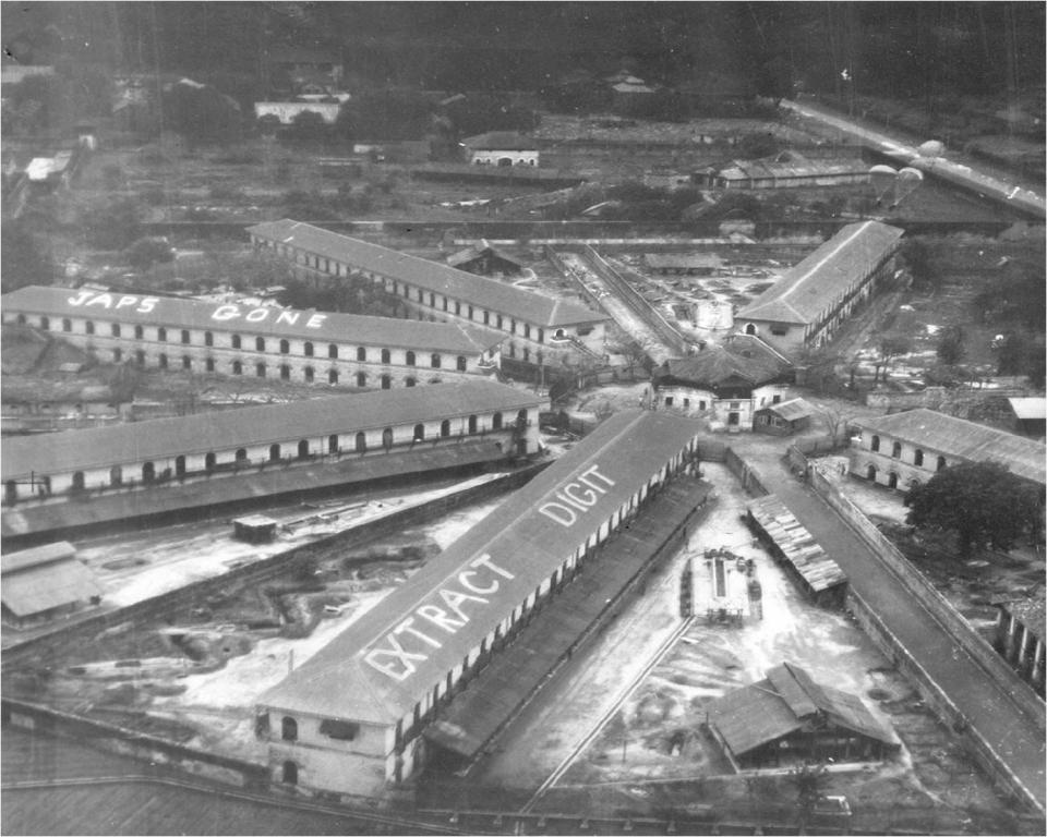 Aerial view of Rangoon Central Jail where Karnig Thomasian was imprisoned by Japanese forces with other captured soldiers from the U.S., British, Australia, New Zealand and China. The photo was taken after Japanese guards abandoned the prison as British forces approached in May 1945.  The messages on the roofs were written by British soldiers.  The "extract digit" message was written to encourage rescuers to take their fingers out of their backsides and rush to the camp as soon as possible.