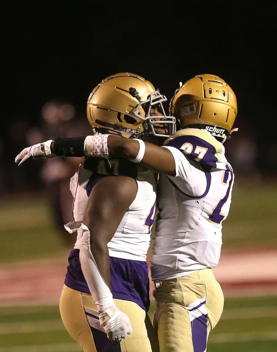 Male’s Kevin Wilson (27) and JaVeon Dorsey celebrated winning after the game against Ballard. Nov. 25, 2022