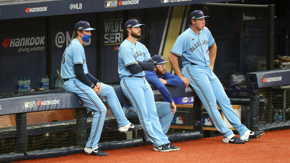 ST. PETERSBURG, FL - SEPTEMBER 30:  Ryan Borucki #56, Thomas Hatch #31, Anthony Kay #47 and Nate Pearson #24 of the Toronto Blue Jays look on from the dugout during Game 2 of the Wild Card Series between the Toronto Blue Jays and the Tampa Bay Rays at Tropicana Field on Wednesday, September 30, 2020 in St. Petersburg, Florida. (Photo by Mike Carlson/MLB Photos via Getty Images)