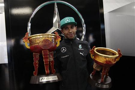 First-placed Mercedes Formula One driver Lewis Hamilton of Britain poses with his trophies during a photo call after the Chinese F1 Grand Prix at the Shanghai International Circuit April 20, 2014. REUTERS/Aly Song