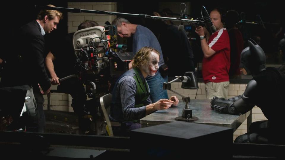 Christopher Nolan, Heath Ledger and Christian Bale prepare to shoot a scene on the set of 'The Dark Knight', 2008