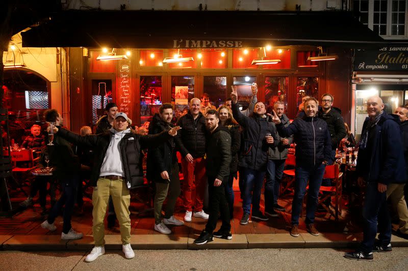 People pose for a picture while enjoying dinner and drinks, after the French Prime Minister announcement that the shut down of no essentials commerces and places will start at midnight in France