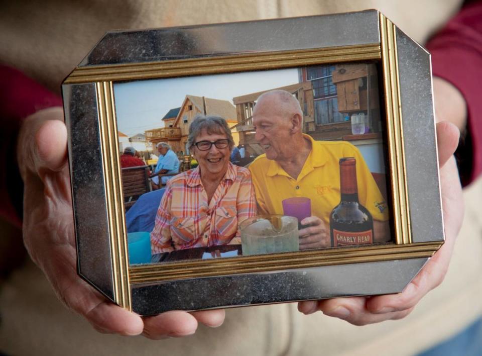 Albert Robinson holds a photograph of himself together with his wife, who died of complications from COVID-19, on Tuesday, Mar. 2, 2021, in Raleigh, N.C.
