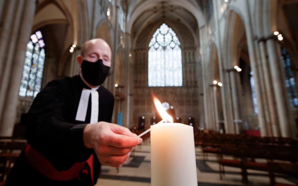 The Revd Michael Smith, York Minster's Canon Pastor, lights a candle during the Minster's Season of Remembrance, which continues today with a special 'Day to Remember' those who have died during 2020. - Danny Lawson /PA 