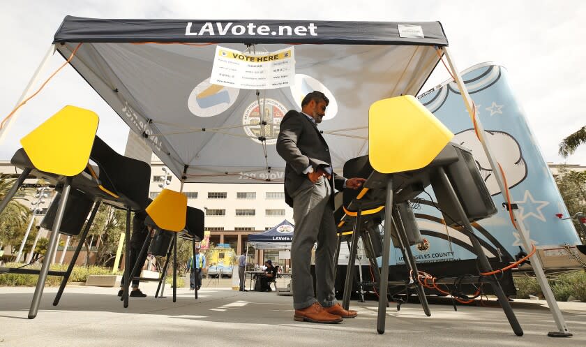 LOS ANGELES, CA - FEBRUARY 27, 2020 Francisco "Franky" Carrillo cast his votes at the Mobile Vote Center assembled in Grand Park as the Los Angeles County Registrar-Recorder/County Clerk is trying to provide voters who live and work in downtown with the opportunity to vote in-person in the 12-acre park through 6 p.m. on Thursday. This is part of the county's transition from polling places to vote centers as residents are able to vote at any vote center and are no longer assigned to a specific polling location for in-person voting. (Al Seib / Los Angeles Times)