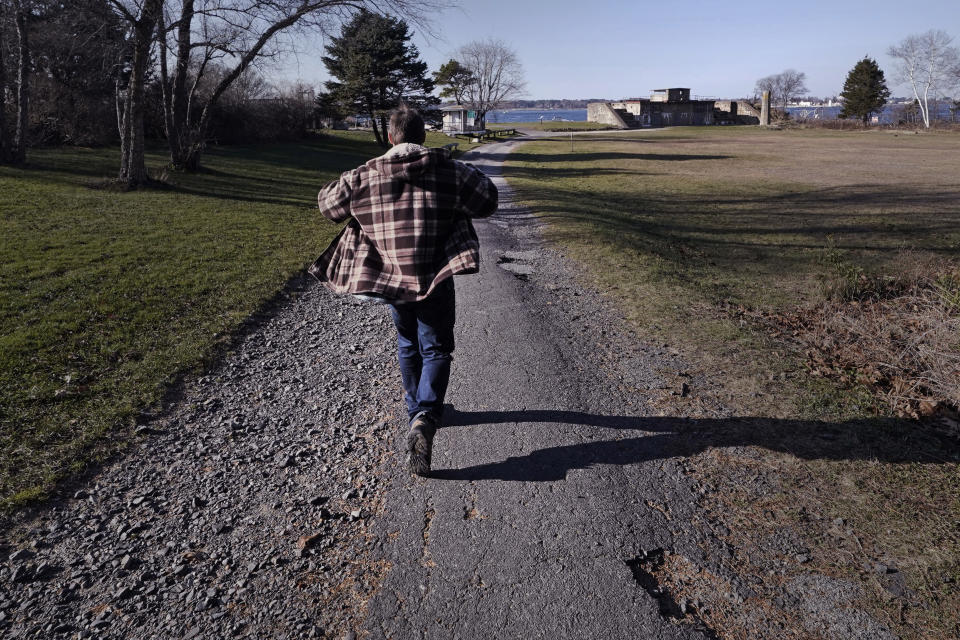 Jacob, an abuse survivor from New Hampshire’s youth detention center, walks down a path at Fort Foster, a place where he finds personal solace, Thursday, Nov. 30, 2023, in Kittery Point, Maine. He says he's frustrated that so few perpetrators have been held accountable. “I am at the point where I want the state to be responsible,” he said. “I want people to know.” (AP Photo/Charles Krupa)