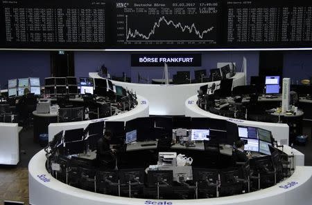 Traders work at their desks in front of the German share price index, DAX board, at the stock exchange in Frankfurt, Germany, March 3, 2017. REUTERS/Staff/Remote