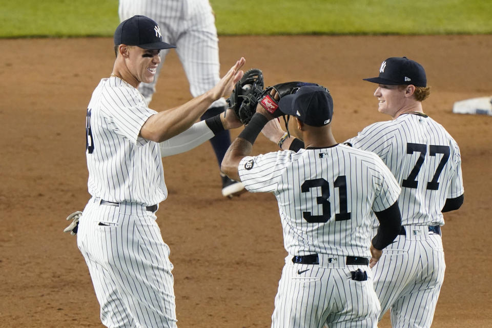New York Yankees right fielder Aaron Judge, left, center fielder Aaron Hicks (31), and left fielder Clint Frazier (77) celebrate the Yankees 3-1 victory over the Atlanta Braves an interleague baseball game, Tuesday, April 20, 2021, at Yankee Stadium in New York. (AP Photo/Kathy Willens)