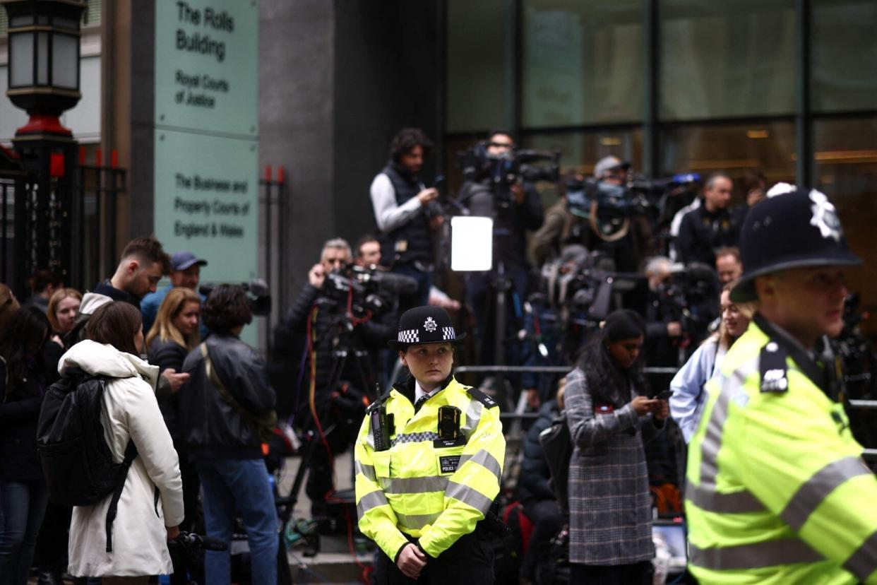Police officers seen stood outside High Court for phone-hacking trial (AFP/Getty)