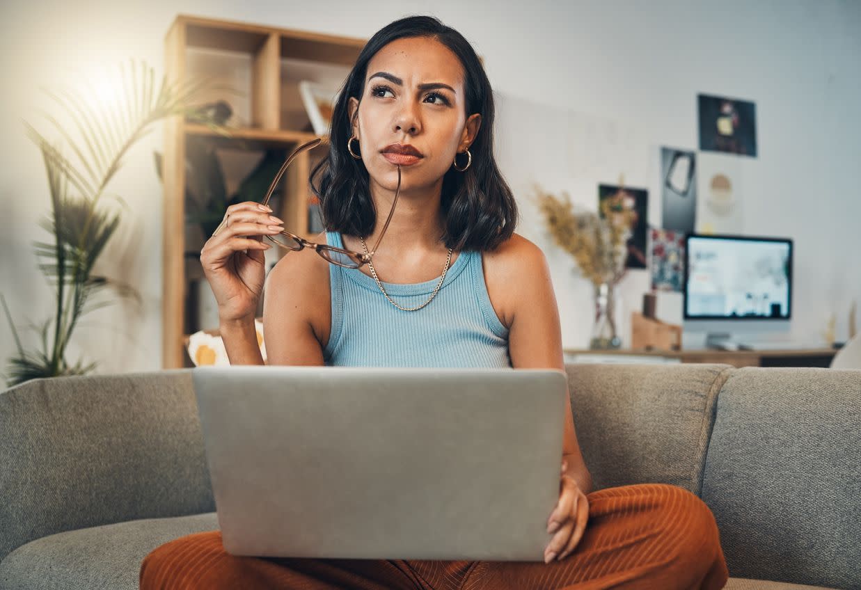 Woman thinking while using laptop