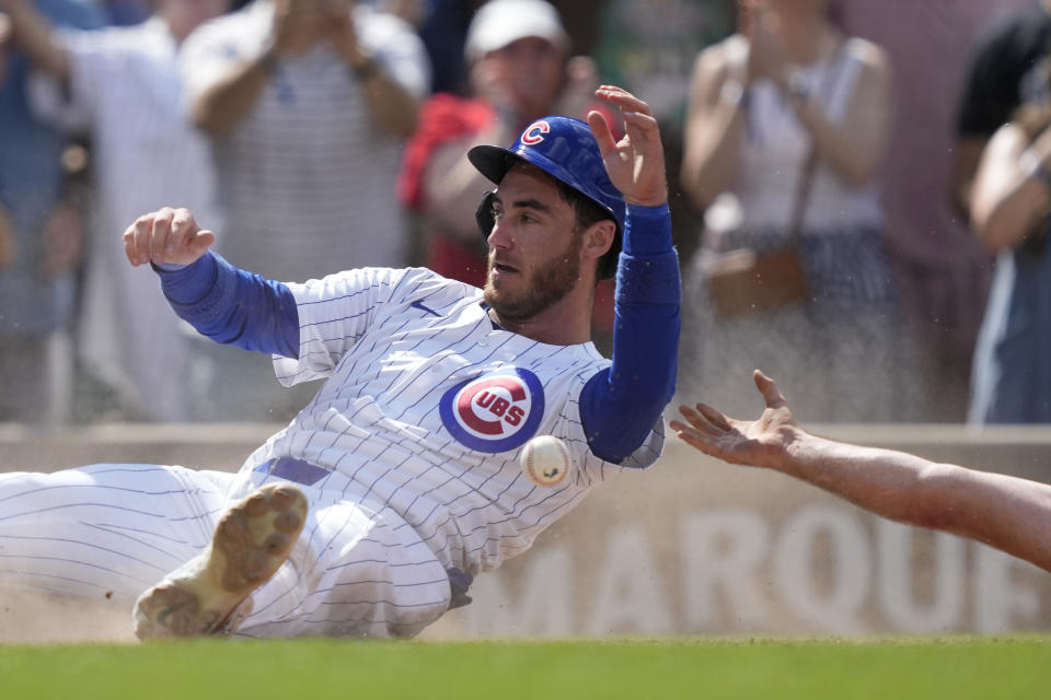 Chicago Cubs' Cody Bellinger scores the winning run past Pittsburgh Pirates catcher Joey Bart off a single by Christopher Morel during the ninth inning of a baseball game Saturday, May 18, 2024, in Chicago. (AP Photo/Charles Rex Arbogast)
