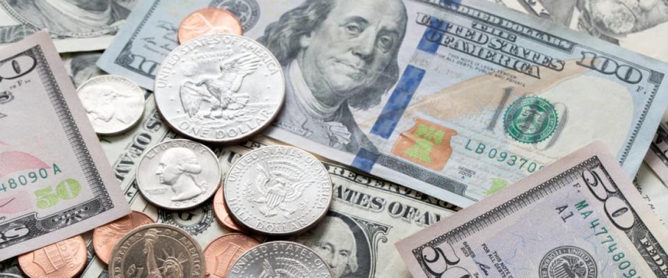 A pile of U.S. dollar bills and coins of different amounts