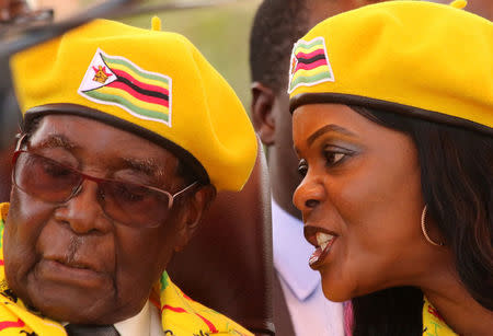 FILE PHOTO: President Robert Mugabe listens to his wife Grace Mugabe at a rally of his ruling ZANU(PF) party in Harare, Zimbabwe, November 8, 2017. REUTERS/Philimon Bulawayo/File Photo