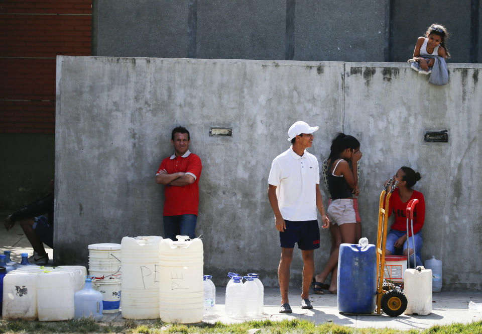 People wait in line to fill up containers with water from a public fountain in Caracas, Venezuela, Tuesday, March 12, 2019. Most people have been deprived of power, water and communications since last Thursday when nationwide power outages first hit, abruptly worsening conditions in a nation already struggling with hyperinflation and shortages of food and medicine. (AP Photo/Fernando Llano)