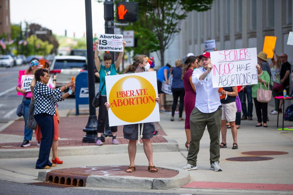 People hold signs at an abortion rights rally Wednesday, June 29, 2022, at the Robert A. Grant Federal Building & U.S. Courthouse in South Bend.