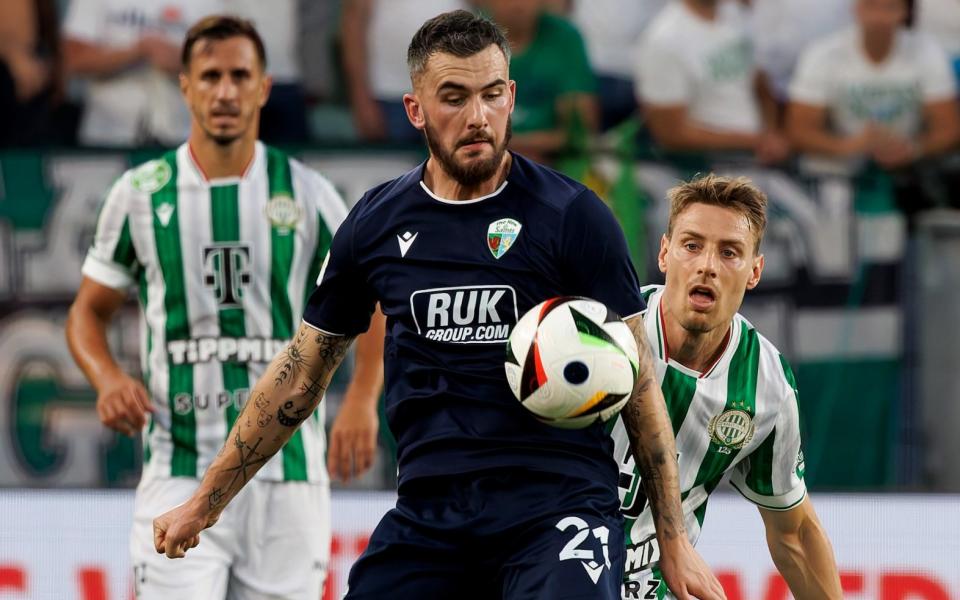 Leo Smith of The New Saints FC competes for the ball with Kristoffer Zachariassen of Ferencvaros during their UEFA Champions League Second Qualifying Round first leg match at Groupama Arena on July 23, 2024 in Budapest, Hungary.