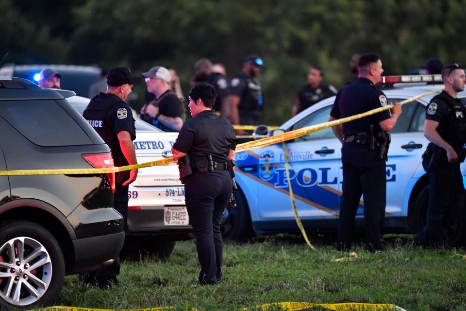Police officers gather at the scene of a shootingat the baseball fields in Shawnee Park, Sunday, July 10 2022 in Louisville Ky.