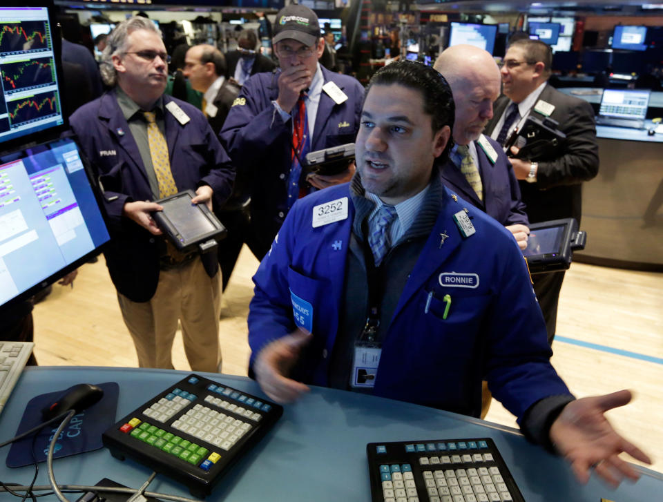 Specialist Ronnie Howard, foreground, works at the post that trades CVS Carremark, on the floor of the New York Stock Exchange, Wednesday, Feb. 5, 2014. The nation's second-largest drugstore chain said Wednesday it will end sales of cigarettes, cigars and chewing tobacco by Oct. 1 as it focuses more on providing health care. (AP Photo/Richard Drew)