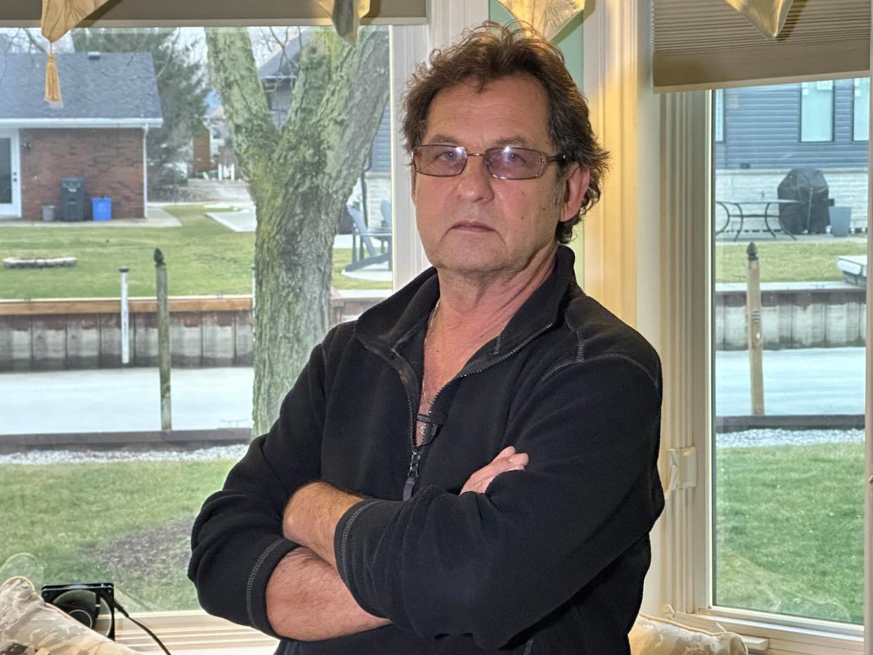 George Olijnyk stands in front of his bedroom where a glaring light from his neighbour wakes him every morning. (Dale Molnar/CBC - image credit)