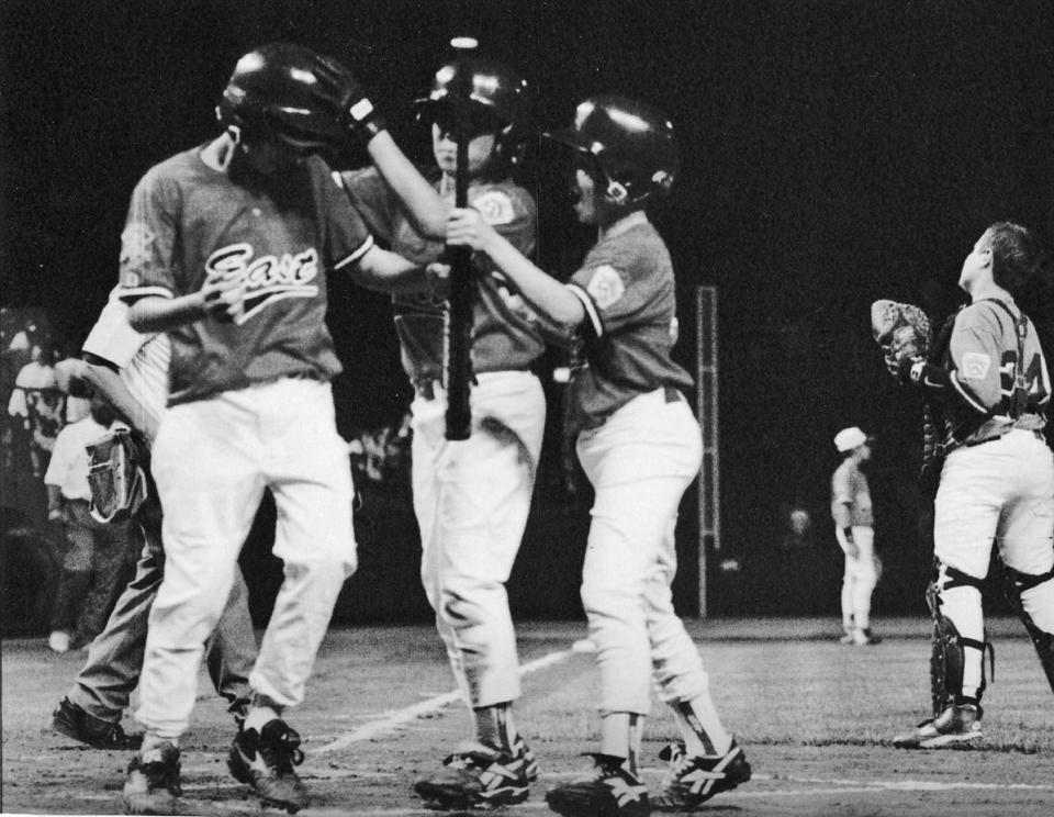 Cranston Western's Brett Bell, left, is congratulated by teammates after he had hit a two-run homer during the 1996 Little League World Series.