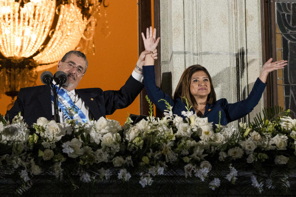 El nuevo presidente de Guatemala, Bernardo Arévalo, y su vicepresidenta, Karin Herrera, saludan a sus seguidores desde el Palacio Nacional tras su investidura en Ciudad de Guatemala, en la madrugada del lunes 15 de enero de 2024. (AP Foto/Moisés Castillo)