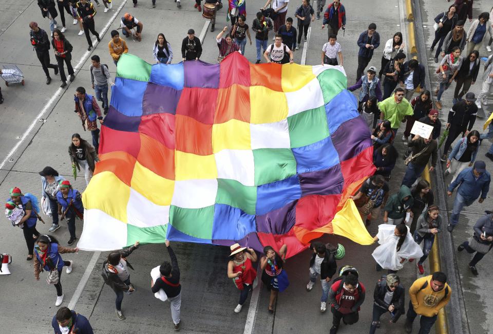 Miembros de la Guardia Indígena y estudiantes marchan con la bandera wiphala durante una protesta antigubernamental en Bogotá, Colombia, el viernes 29 de noviembre de 2019. (AP Foto/Fernando Vergara)