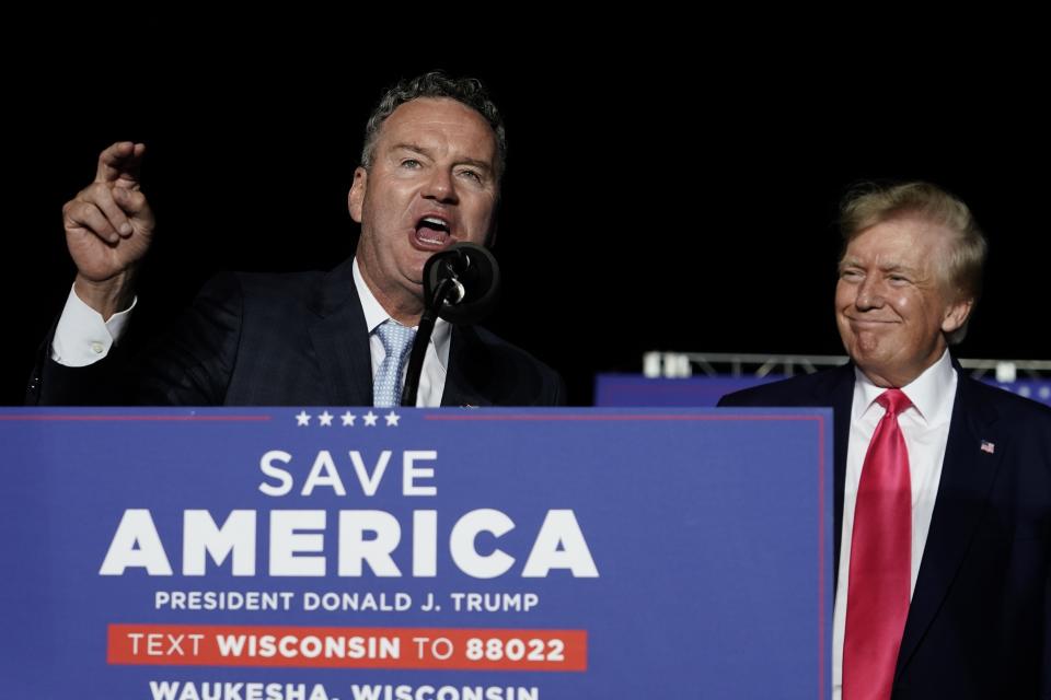 FILE - Wisconsin Republican gubernatorial candidate Tim Michels, left, speaks as former President Donald Trump, right, listens at a rally in Waukesha, Wis., on Friday, Aug. 5, 2022. Republican candidate for Wisconsin governor Rebecca Kleefisch downplayed Trump's endorsement and rally for her opponent, Michels, on a final campaign push across Wisconsin on Monday, Aug. 8, 2022, declining to respond to the former president's criticisms of her. (AP Photo/Morry Gash, File)