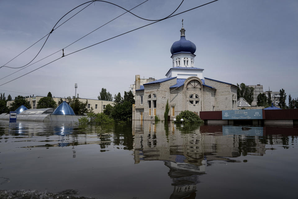 Una iglesia, rodada de agua en un vecindario inundado en Jersón, Ucrania, el 8 de junio de 2023. Las masivas inundaciones causadas por la destrucción de la represa de Kajovka el 6 de junio han arrasado pueblos situados río abajo en ambas orillas del Dniéper, en la región de Jersón, que está en la línea del frente de la guerra. Rusia y Ucrania se acusan mutuamente de provocar el colapso. (AP Foto/Evgeniy Maloletka)