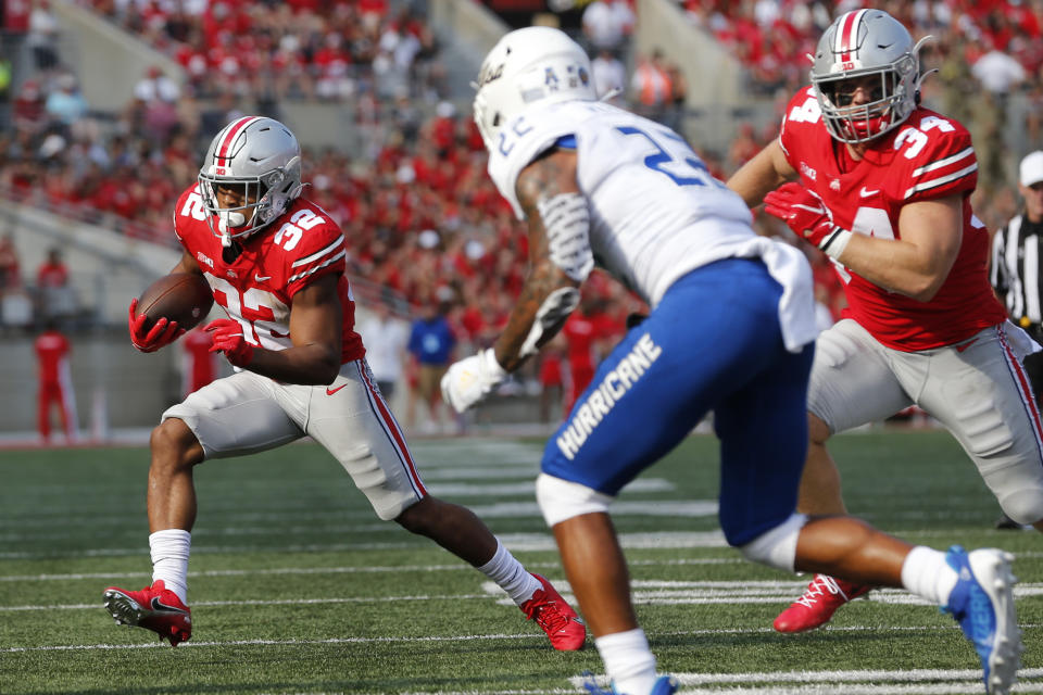 Ohio State running back TreVeyon Henderson, left, cuts upfield against Tulsa defensive back LJ Wallace during the first half of an NCAA college football game Saturday, Sept. 18, 2021, in Columbus, Ohio. (AP Photo/Jay LaPrete)